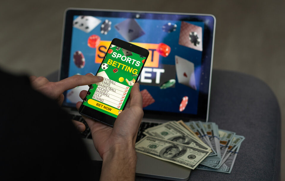 Businessman using smartphone against gambling app screen